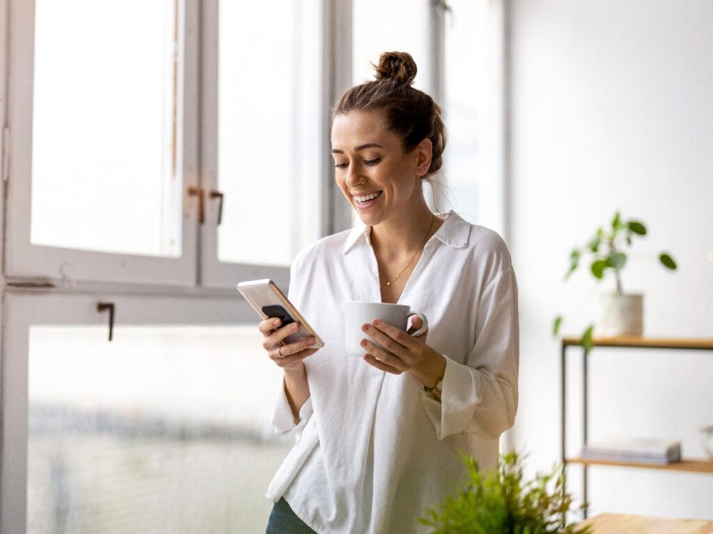 Creative business woman using smartphone in loft office